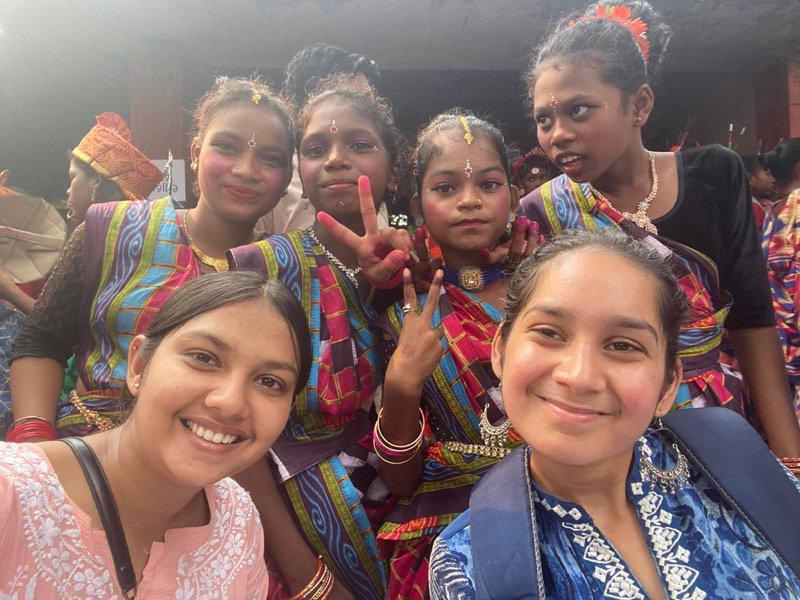 Sanya Ghai with young girls in traditional Odisha folk dance costumes during a community program